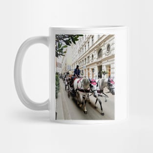 White horses adorned in formal regalia pulling carriages in city street. Mug